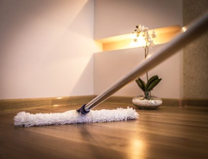 Modern white mop cleaning wooden floor in house